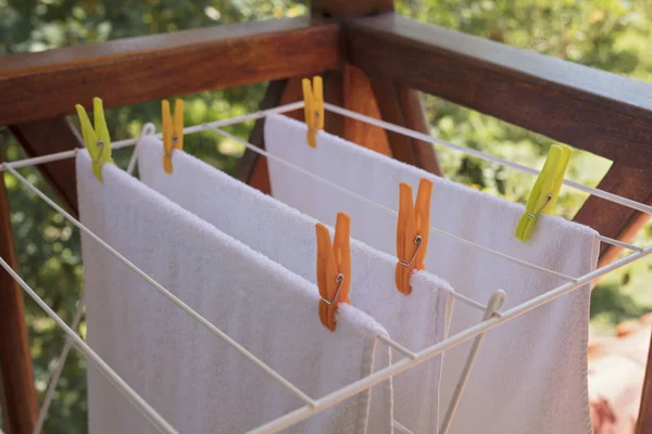 Lavandería secado, toallas blancas limpias en un caballo de la ropa afuera . — Foto de Stock