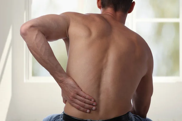 Lesión deportiva, hombre con dolor de espalda. Alivio del dolor y concepto de atención médica . — Foto de Stock