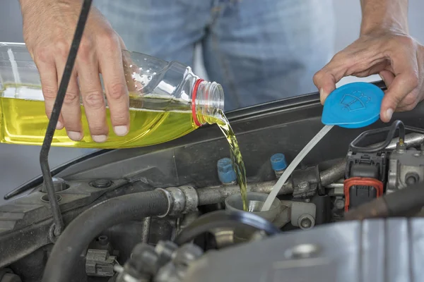 앞유리 액체입니다. 그의 차 바람막이 청소 액체를 추가 하는 남자. — 스톡 사진