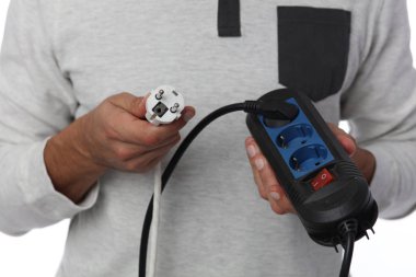 Enerji tasarrufu kavramı. Elektrik güç uzatma kablosu tutan adam.