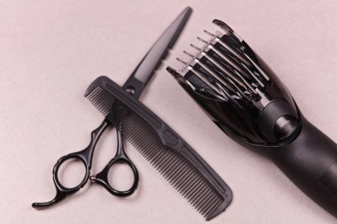Kuaför araçları: makas, tarak ve gri arka plan üzerinde saç şekillendirme için hassas düzeltici