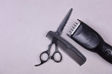 Kuaför araçları: makas, tarak ve gri arka plan üzerinde saç şekillendirme için hassas düzeltici