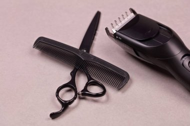 Kuaför araçları: makas, tarak ve gri arka plan üzerinde saç şekillendirme için hassas düzeltici