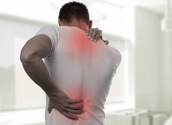 Muscular Man suffering from back and neck pain. Incorrect sitting posture problems Muscle spasm, rheumatism. Pain relief, ,chiropractic concept. Sport exercising injury — Stock Photo, Image