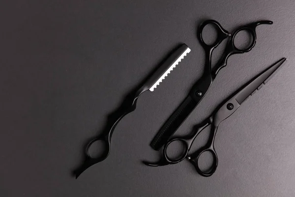 Stylish Professional Barber Scissors, Hair Cutting and Thinning Scissors o ndarkbackground. Hairdresser salon concept, Hairdressing Set. Haircut accessories. Copy space image, flat lay