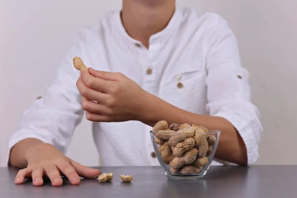Criança a comer amendoins. Conceito de alergia alimentar — Fotografia de Stock