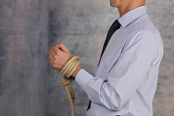 Biznesmen z liny przywiązane ręce. Zasady, prawo nie pozwala, ograniczenia i limity w pracy. — Zdjęcie stockowe