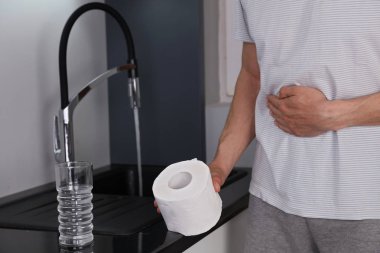 Adam acı mide ağrısı ve ishal musluk suyu içtikten sonra. Bacteriologically uygun su, sanitasyon ve hijyen kavramı.