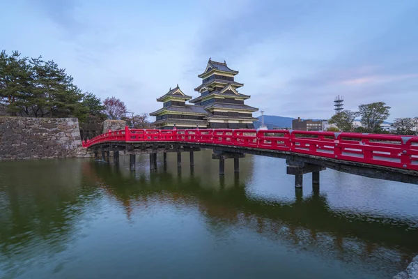 Matsumoto Castle at twilight with the red bridge in Nagano, Japan. — Stock Photo, Image