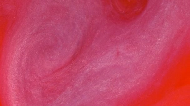 Запись 4К. Чернила в воде. Красные чернила реагируют в воде, создавая абстрактный фон . — стоковое видео