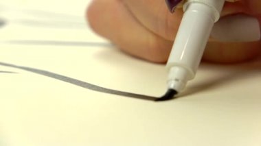 Uyuşuk görüntüleri. Sanatçı kız ele siyah çizgi fırça kalem çekin. Yakın çekim