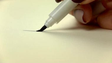 Uyuşuk görüntüleri. Sanatçı kız ele siyah çizgi fırça kalem çekin. Yakın çekim