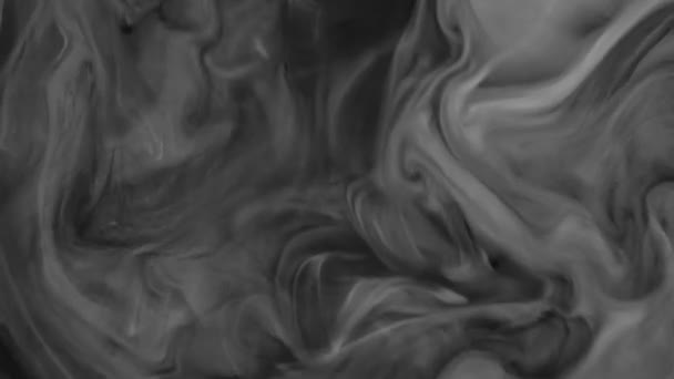 Запись 4К. Чернила в воде. Черные чернила смешиваются в воде, создавая абстрактный фон . — стоковое видео