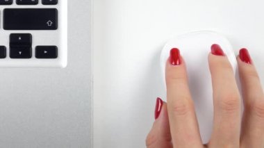 4 k görüntüleri. Kadının sağ eli ile kırmızı manikür kablosuz bilgisayar fare kullanma. Üstten Görünüm. Yakın çekim