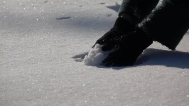 Uyuşuk görüntüleri. Kadın, karlı kış günü dışında kartopu yapar.