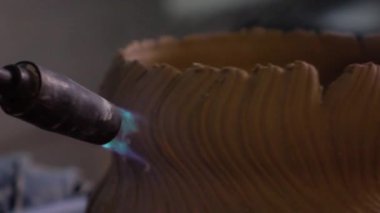 Potter Gaz yakıcı ile pota yakar. Ağır çekim. Yakın çekim