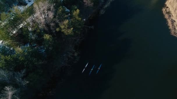 4k видео с воздуха. Верхний вид весной поворачивает три каяка на реке — стоковое видео