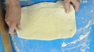 Ağır çekim görüntüleri. Baker el oklava ile hamur yoğurma. Üstten Görünüm