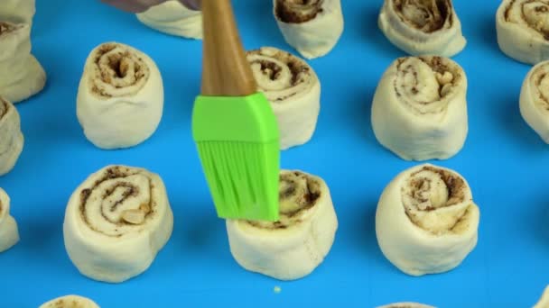 Slow motion footage. Lubrication egg cinnamon rolls before they come into the oven — Stock Video