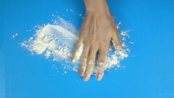 スローモーション映像。ベイカーの手がテーブルの上に小麦粉を投げします。トップ ビュー — ストック動画