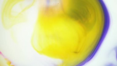Suda mürekkep. Sarı ve mor mürekkep suda reaksiyona girerek soyut bir arkaplan oluşturuyor.