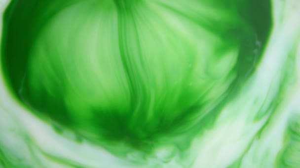 4K beelden. Inkt in het water. Groene inkt reageert in water en creëert een abstracte achtergrond. — Stockvideo