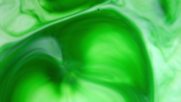 4K beelden. Inkt in het water. Groene inkt reageert in water en creëert een abstracte achtergrond. — Stockvideo