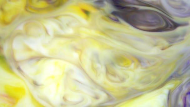 Tinte in Wasser. Gelbe und violette Tinte, die im Wasser reagiert und einen abstrakten Hintergrund erzeugt. — Stockvideo