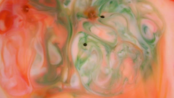 4K beelden. Inkt in het water. Rode en oranje inkt reageren in water creëren abstracte achtergrond. — Stockvideo