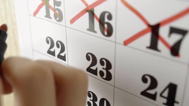 La mano femminile attraversa con il marcatore rosso il giorno del calendario 22. Colpo lento. Da vicino. — Video Stock