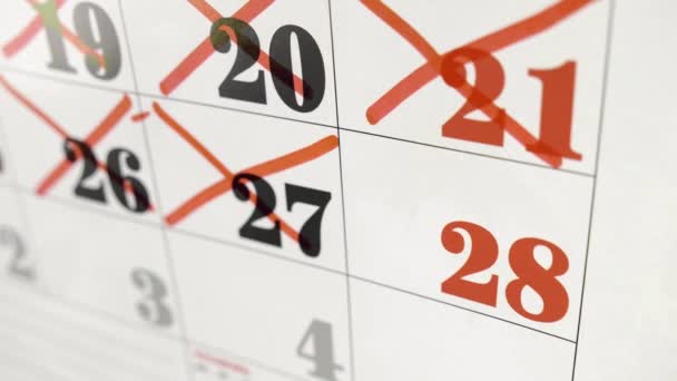 La mano femminile attraversa con il marcatore rosso il giorno del calendario 28. Colpo lento. Da vicino. — Video Stock