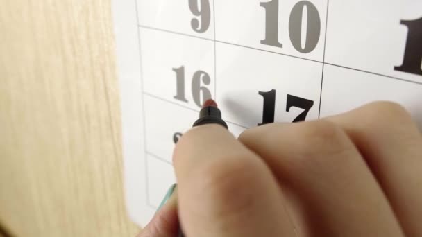 Női kézjegyzetek születési napja piros jelölővel a 17. naptári napon. Lassított felvétel. Közelről. — Stock videók
