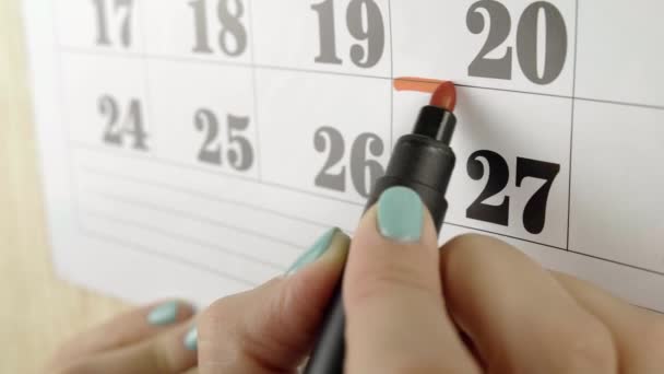 Το γυναικείο χέρι περικυκλώνει το τετράγωνο με κόκκινο μαρκαδόρο την 27η ημερολογιακή ημέρα. Αργή κίνηση. Κλείσε. — Αρχείο Βίντεο
