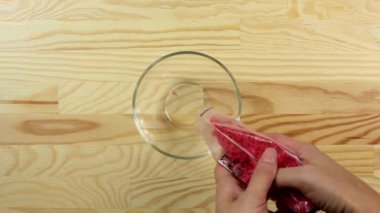 Kadın kalp şekeri döküyor cam bir kaseye nokta serpiştiriyor.