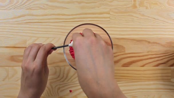 Una mujer espolvorea pastel de corazón estallido con aderezo rojo, vista superior — Vídeos de Stock