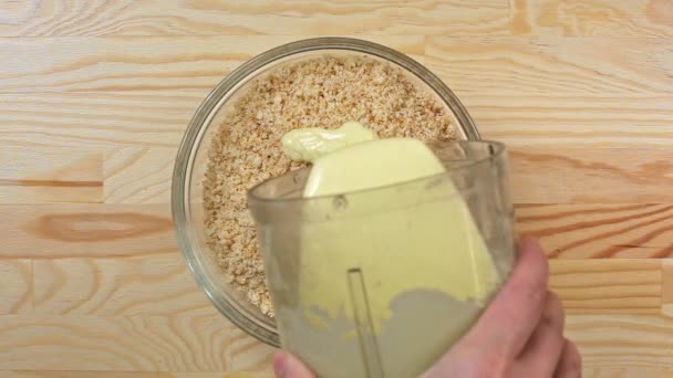 Le cuisinier verse le lait condensé dans une miette de biscuit, vue de dessus — Video