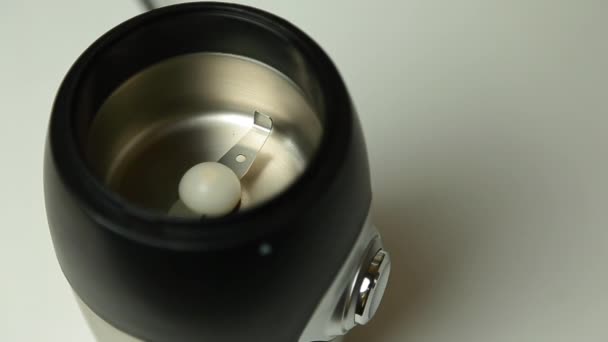 Roasted coffee beans poured into a coffee grinder, top view — Stock Video