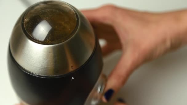 Женщина закрывает руку и включает кофемолку — стоковое видео