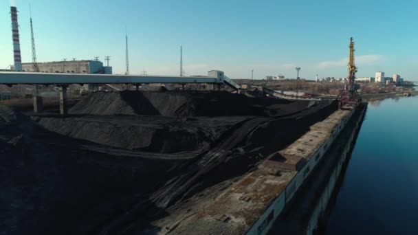 Vista aérea del almacén de carbón abierto cerca del río con grúa y transportador — Vídeo de stock