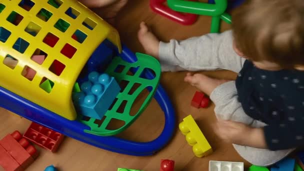 Niño juega con kit de diseño en el suelo, vista superior — Vídeo de stock