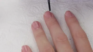 Genç bir kadın, yapışmayı desteklemek için tırnaklarına astar dehidratör bağını uyguluyor. Manikür.