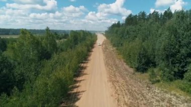 Desyatyny, Ukrayna - 8 Temmuz 2018: Rally arabası köyün yakınındaki çakıl taşlı bölümden geçiyor, arkasında toz izi bırakıyor.