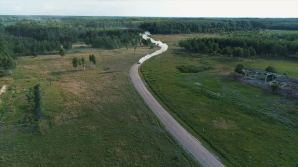 Desyatyny, Ucrânia - 8 de julho de 2018: Vista aérea. Carro de rali passa seção de cascalho da pista perto da aldeia, deixa para trás uma trilha de poeira — Vídeo de Stock