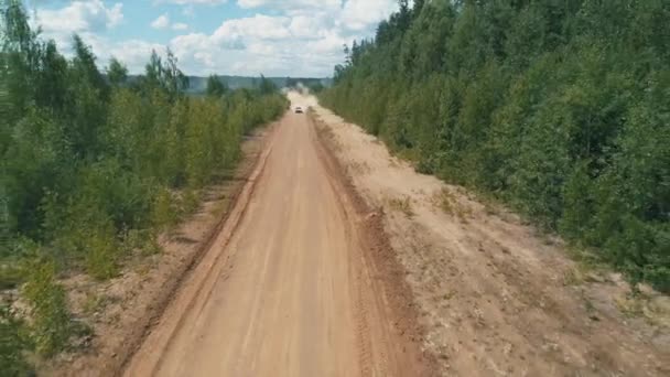 Desyatyny, Oekraïne - 8 juli 2018: Luchtfoto. Rally auto passeert grind deel van het spoor in de buurt van het dorp, laat achter een stofspoor — Stockvideo
