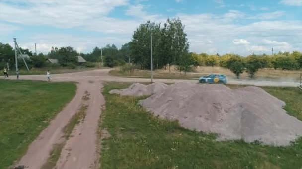 Desyatyny,ウクライナ- 2018年7月8日:航空写真。ラリーカーは村の近くのトラックの砂利のコーナーを通過し、ほこりの歩道の後ろに残します — ストック動画