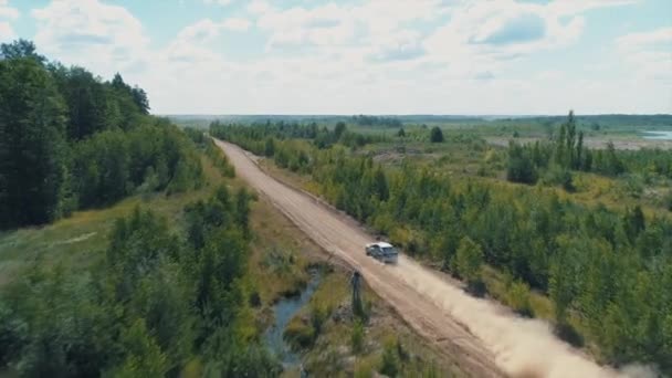 Desyatyny, Ukrajna - július 8, 2018: Légi felvétel. Rally autó halad kavicsos részén a pálya közelében a falu, hagy hátra egy pornyomot — Stock videók