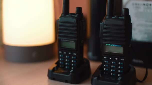 Due spegnere walkie-talkie stand sul tavolo. Dolly movimento primo piano colpo — Video Stock