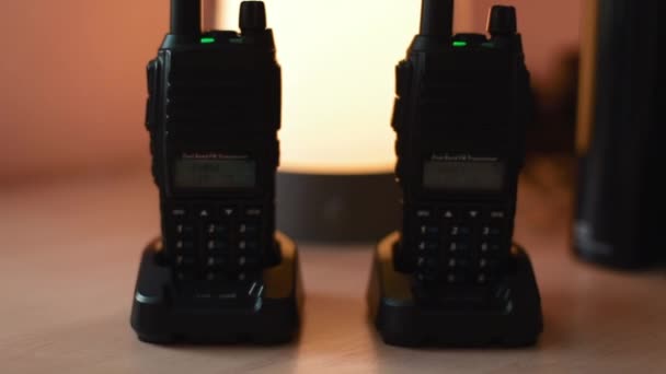 Two turn on working walkie-talkie stand on the table. Dolly movement close-up shot — Stock Video