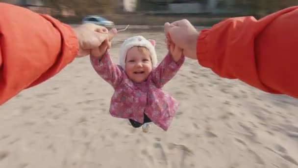 Lassú mozgású apa forog a kislányával, fogja a kezét a parton. POV — Stock videók