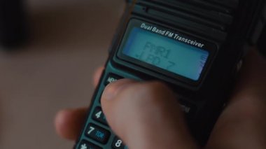 Telsizi tut ve radyo kanallarını kapalı kapılar ardında makroyu değiştir.